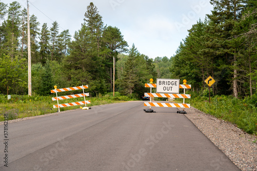 Orange and white striped road sign that reads 