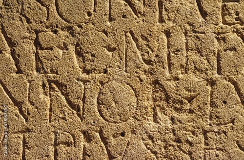 roman inscription in brown stone in bath, united kingdom
