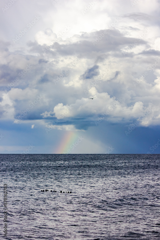 Russia, Kaliningrad region, rainbow and lightning after a storm in the Baltic Sea. Thunderclouds and the sea.