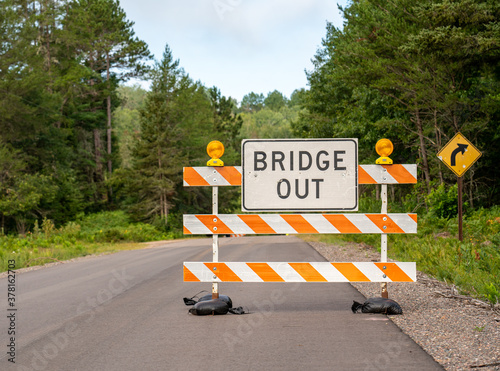 Orange and white striped road sign that reads 