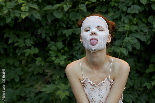 Vászonkép Nice woman Anti-wrinkle mask She leaned forward and sticks out her tongue bare s