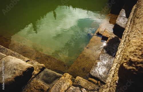 water and buildings in an old roman bath in the city of Bath in the united kingdom