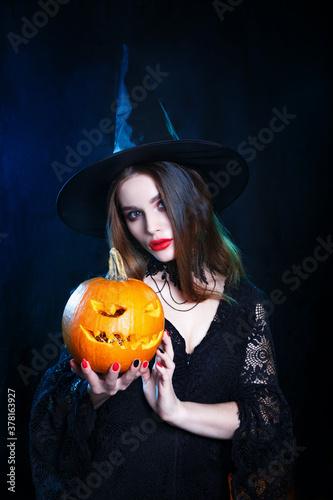 Happy Halloween . Halloween witch with a magic pumpkin on black background.