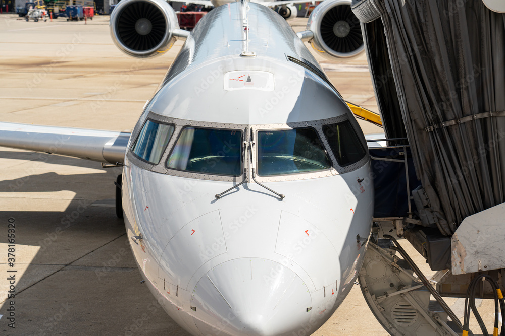 White airplane with jet bridge pulled up to it White airplane with jet bridge pulled up to it