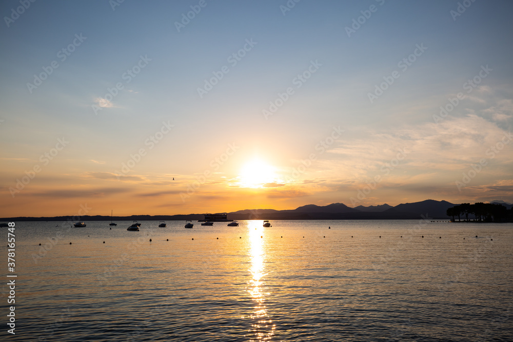 Sunset in Bardolino on Lake Garda with mountains in the background Sunset in Bardolino on Lake Garda with mountains in the background