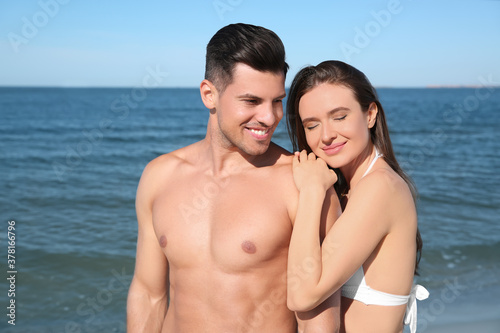 Woman in bikini and her boyfriend on beach. Happy couple © New Africa