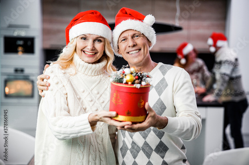 Happy loving couple holding present box in hands