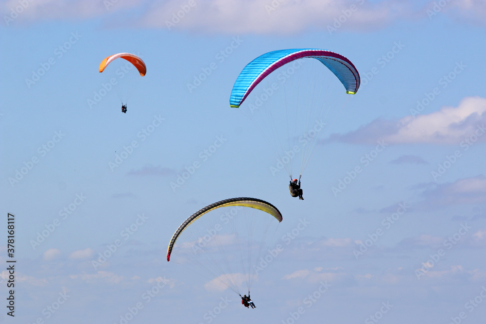 Paragliders flying wing in a blue sky Paragliders flying wing in a blue sky