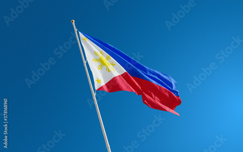 Isolated Philippines flag waving in the wind against blue sky background. Philippines national flag close up