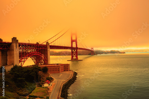 Smoky orange sky on Golden Gate Bridge of San Francisco skyline from Fort point. Californian fires in September 2020 in United States. Wildfires composition.