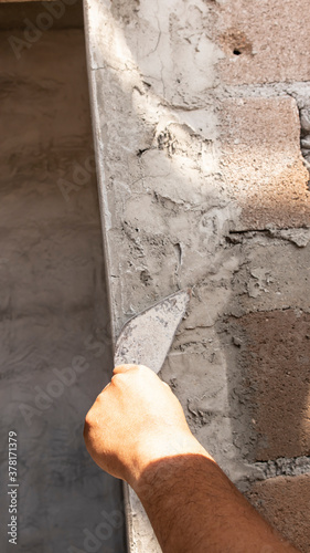 Tiler's hand.bricklayer plaster a wall inside a building