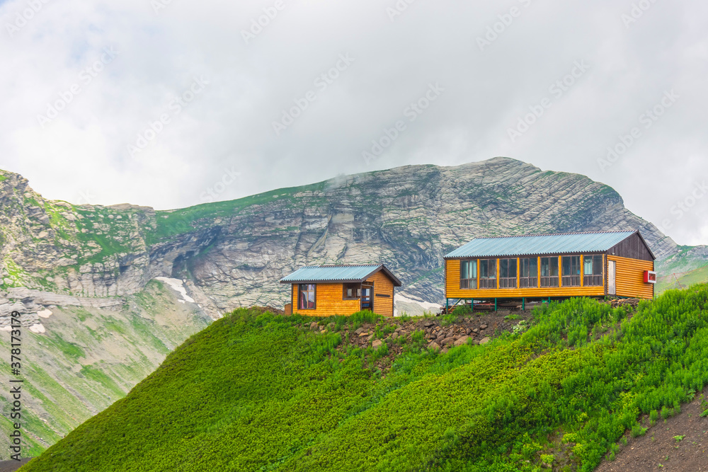 Two wooden houses on top of a mountain.