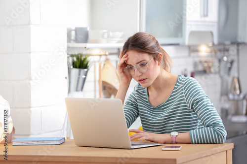 Quadro em tela Troubled young woman working on laptop at home