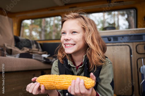 Portrait of young girl holding corn photo
