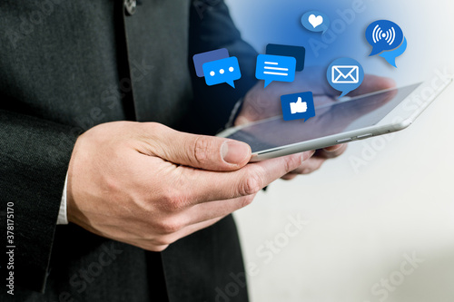 Executive hands holding a tablet with social media icons