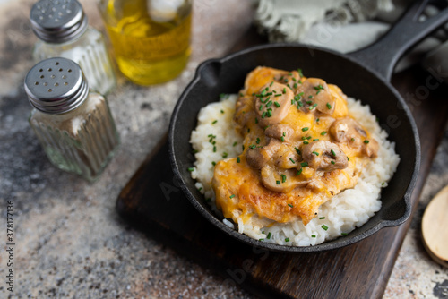 Chicken Lombardy made with five cheese and mushrooms over white rice 