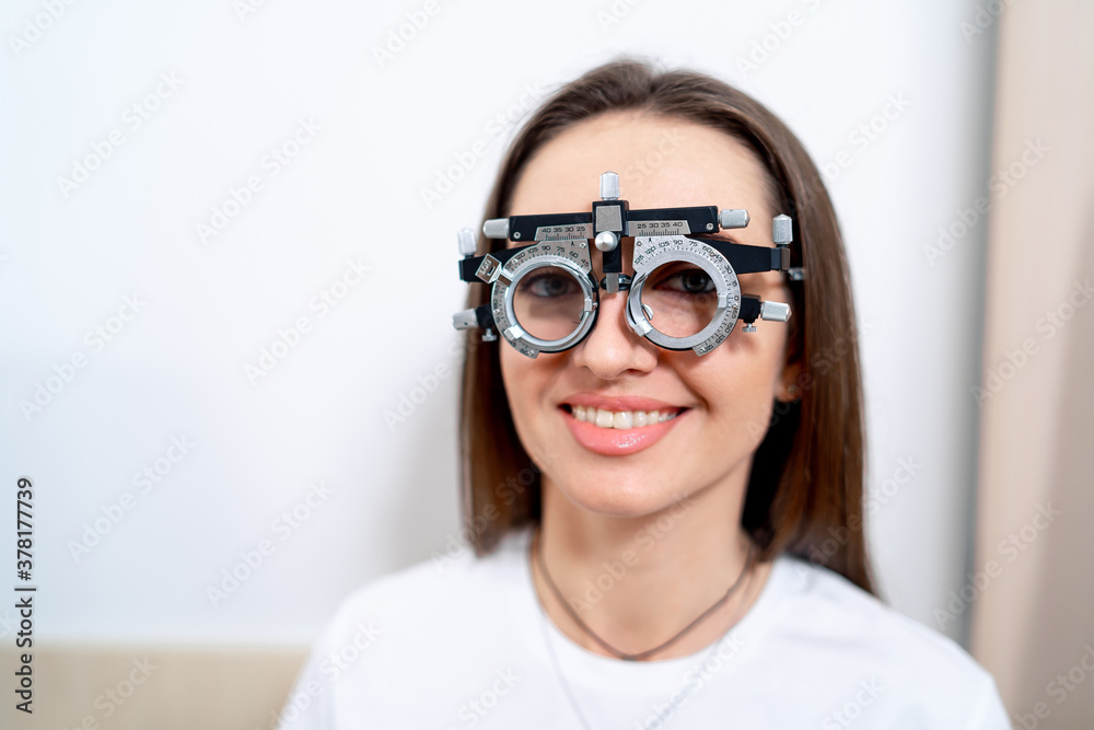 Portrait of woman wearing corrective glasses with replaceable lenses. Ophthalmology clinic.