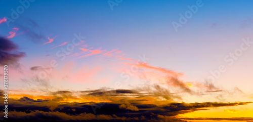 autumn sunset sky landscape background panorama. Natural color of evening dark clouds. Cloudscape with sun below horizon. Ultra wide panoramic view