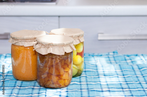 Glass jurs of various preserved, canned foon in the kitchen in sunny day. photo