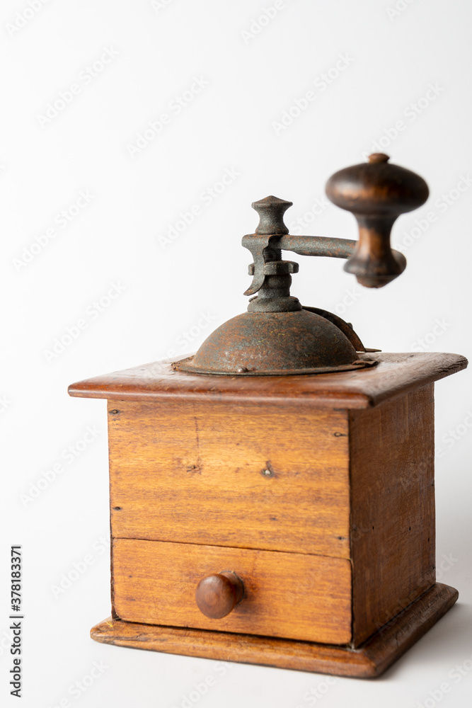 Close-up of old wooden coffee grinder, sideways, with defocused handle, on white background, vertical, with copy space Close-up of old wooden coffee grinder, sideways, with defocused handle, on white background, vertical, with copy space
