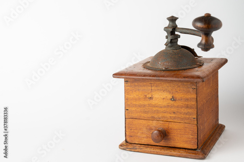 Close-up of old wooden coffee grinder, sideways, with unfocused handle, on white background, horizontal, with copy space