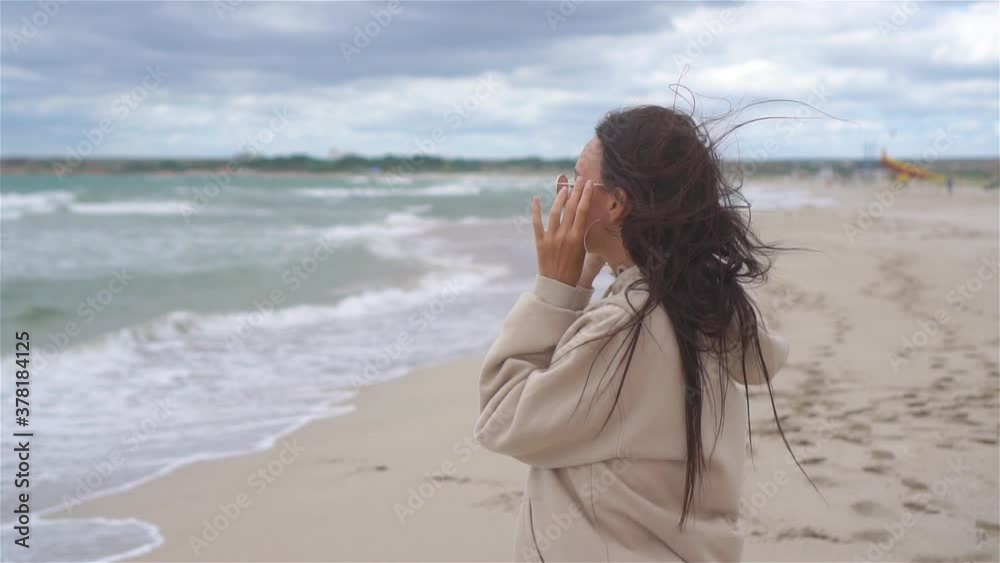 Young woman on the beach in the storm