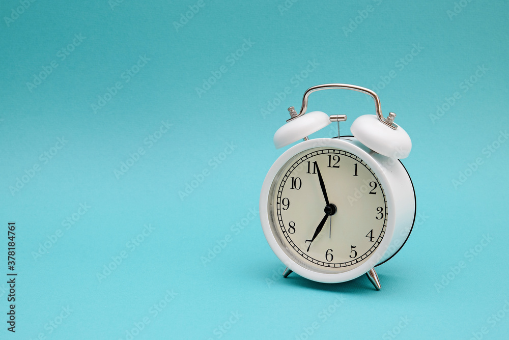 White alarm clock photography on blue background White alarm clock photography on blue background