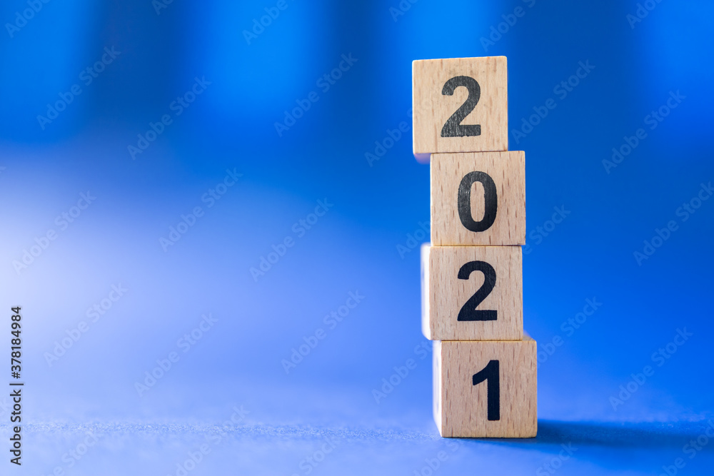 2021 New Year Concept. Closeup of wooden number block toy on blue background with copy space.