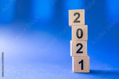 2021 New Year Concept. Closeup of wooden number block toy on blue background with copy space.