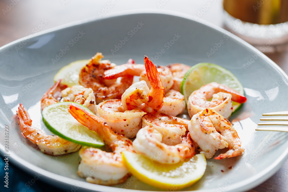 Fried tiger shrimp with lime, lemon and spices on a ceramic dish. Healthy dinner or lunch concept. Fried tiger shrimp with lime, lemon and spices on a ceramic dish. Healthy dinner or lunch concept.