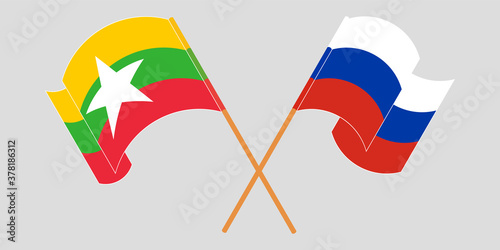 Crossed and waving flags of Myanmar and Russia