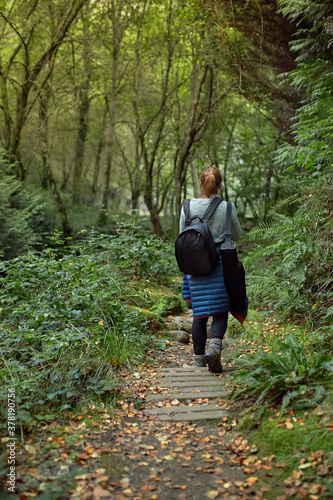 View from behind of a girl walking along a forest path.