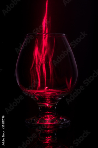 Cognac glass with fire.Fiery glass on a black background.