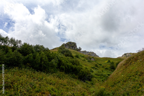 Panorama of mountains and subalpine meadows covered with vegetation in the summer - places to visit and walk for tourists and outdoor enthusiasts.