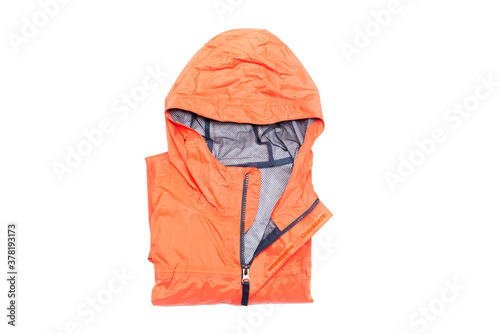 Folded orange zipper windbreaker jacket, rain proof and waterproof hiking Gore-Tex jacket hoodie. Track jacket sport nylon full zip isolated on white. Folded clothes. Outer layer garment for travel.