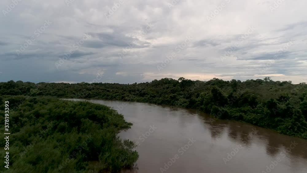 Aerial view fast over a river, revealing wetlands and tropical forest, dark, gloomy day, in Pantanal, Brazil - rising, drone shot Aerial view fast over a river, revealing wetlands and tropical forest, dark, gloomy day, in Pantanal, Brazil - rising, drone shot