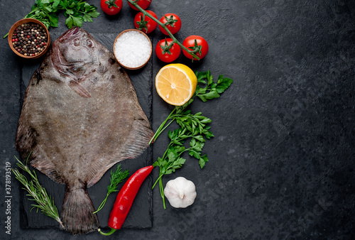 Canvas Print raw flounder with spices on a stone background with copy space for your text