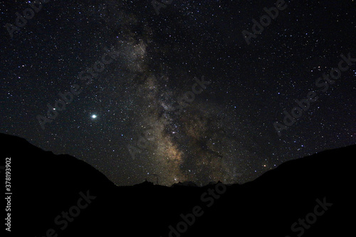 Starry sky and milky way in the mountains. Mountain village against the background of the night starry sky and the milky way.