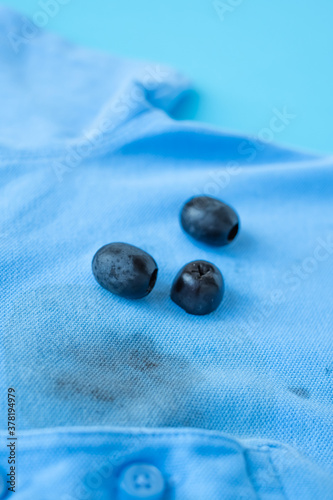 close up dirty stain of black olives on clothes