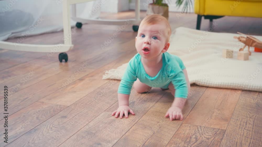 infant boy looking at camera while crawling at home infant boy looking at camera while crawling at home