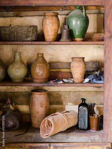 Old shelves stocked with handmade urns and pottery photo