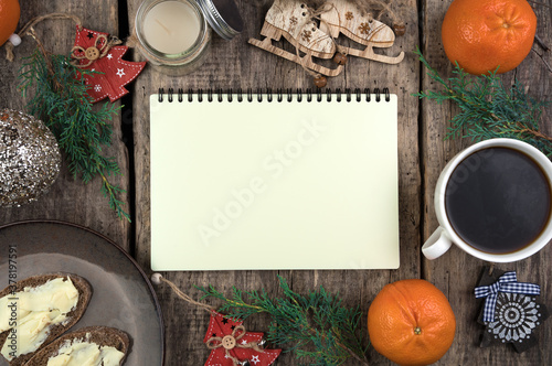 Coniferous branches, Tangerines, a Cup of coffee and sandwiches, a Notepad and a retro camera on a natural wooden background. Cozy Christmas composition. The concept of New year and Christmas.