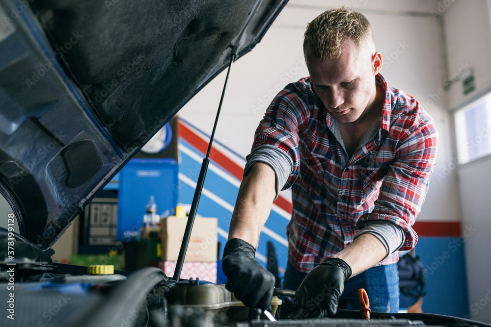 Man working with car engine in service Man working with car engine in service