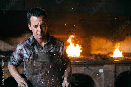Blacksmith working near hearth