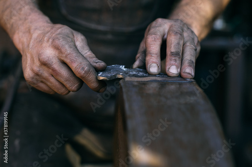 Crop blacksmith sharping blade photo