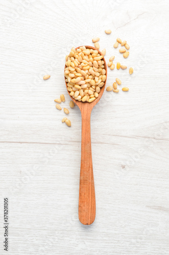 Cedar nuts in a wooden spoon.Top view. Free space for your text.