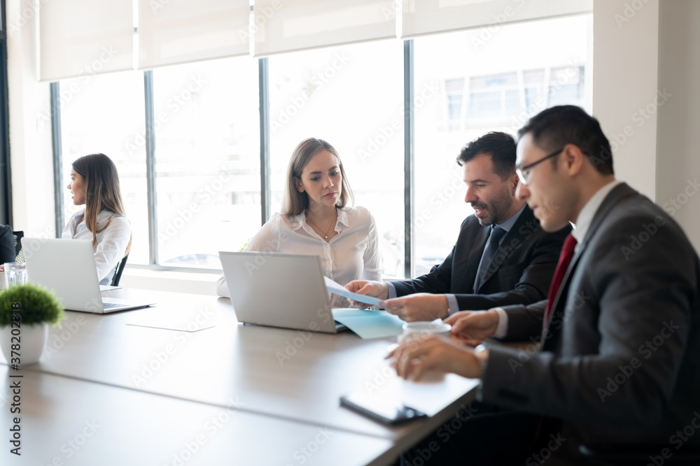 Business team reviewing paperwork in a meeting Business team reviewing paperwork in a meeting
