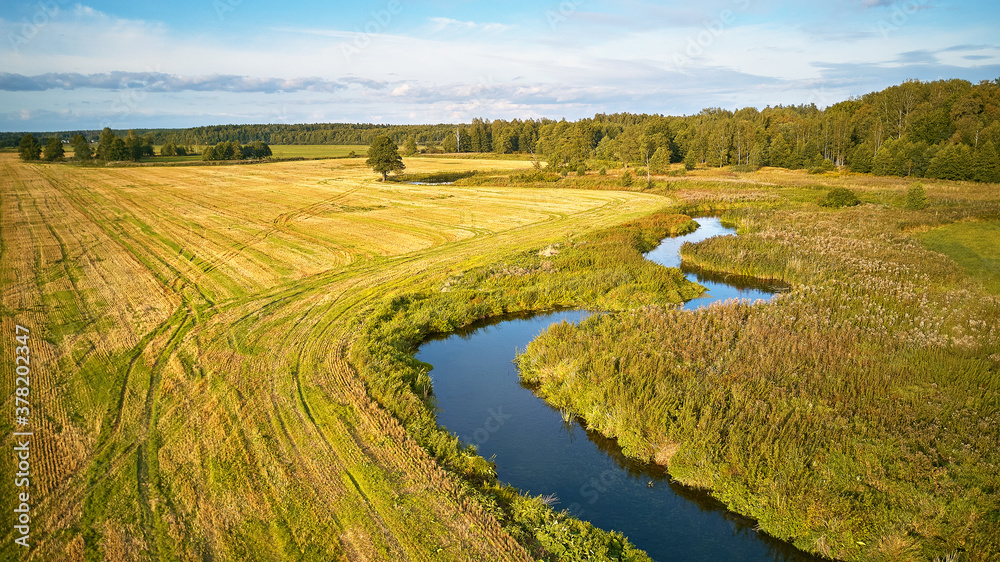 Agriculture fields after harvest, sunny September day. Autumn landscape in evening sunlight from above