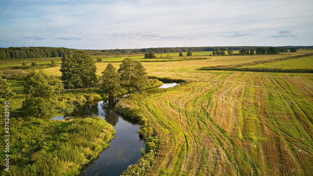 Autumn landscape in evening sunlight from above. Agriculture fields after harvest
