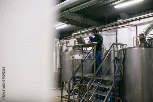 Brewery engineer making notes during work photo